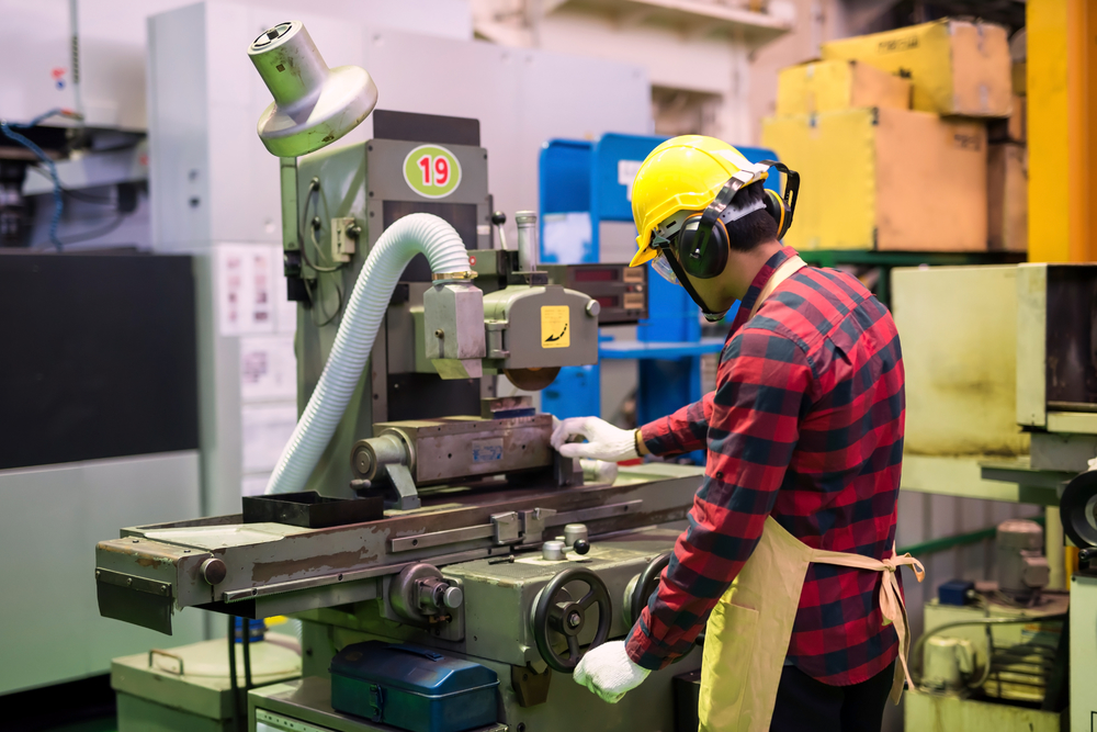工厂机械专业工人与头盔和玻璃工作的漆树金属生产五金自动化机械背景重工业安全第一